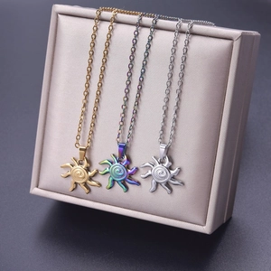 Detailed sun pendant necklaces in gold, rainbow, and silver finishes displayed on a stand
