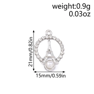 Macro shot of silver Eiffel Tower pendant with rhinestones and pearl showing dimensions