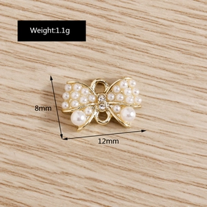 Détail macro de breloques nœud en perles et strass de 12mm x 8mm pour bijoux DIY