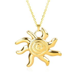 Macro shot of gold sun pendant necklace with spiral relief and polished metal finish