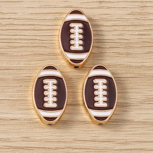 Macro detail of three alloy American football charms with brown enamel and gold plating