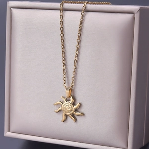 Detail of 18k gold plated sun pendant necklace with spiral texture on a jewelry box