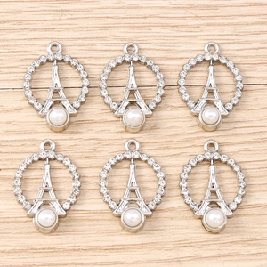 Detailed macro view of Eiffel Tower charms with sparkling rhinestones and pearl accents