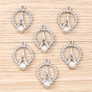 Macro view of silver Eiffel Tower charms with sparkling rhinestones and white pearls