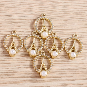 Detailed view of gold Eiffel Tower charms with rhinestones and pearl accents for DIY