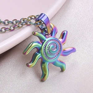 Macro detail of rainbow gradient sun pendant with spiral center on an O-link chain