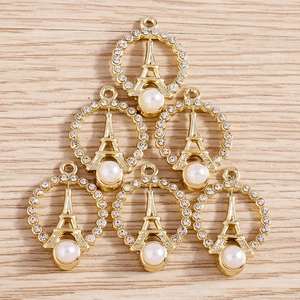 Detailed close-up of Eiffel Tower gold pendants with rhinestones and white pearls
