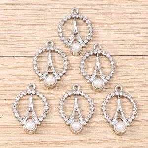 Close-up of Eiffel Tower charms with rhinestones and white pearls for DIY jewelry making
