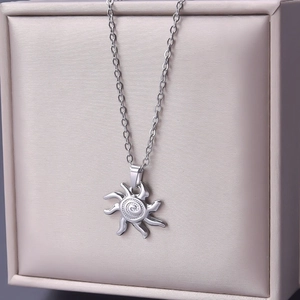 Detailed view of silver stainless steel sunburst pendant necklace in luxury display box