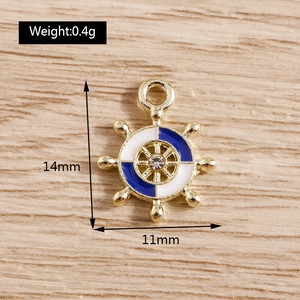 Macro detail of nautical ship wheel pendant with blue enamel and crystal accent