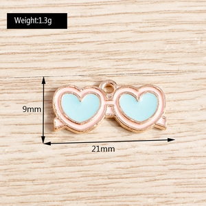 Dettaglio del ciondolo a occhiali a cuore rosa e blu con indicazione misura 21x9mm