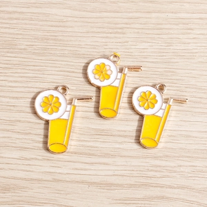 Macro detail of three lemon drink enamel pendants with gold plating for DIY jewelry
