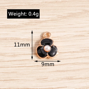 Détail d'un pendentif fleur en émail noir avec perle centrale et dimensions de 11 mm