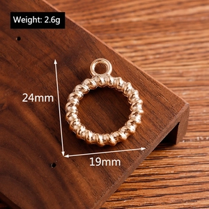 Detailed view of golden twisted ring alloy pendant with size markings on wooden background