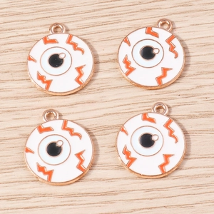 Gros plan de quatre pendentifs œil en émail avec bordure en or rose pour bijoux DIY