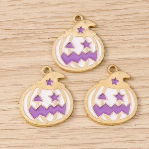 Détail macro de trois breloques citrouilles en émail pour bijoux d'Halloween