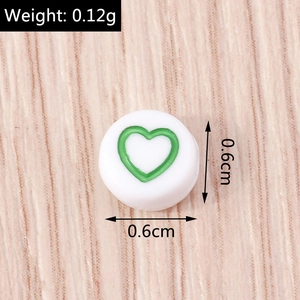 Dettaglio macro di una perla rotonda bianca da 0,6 cm con cuore verde per gioielli fai-da-te