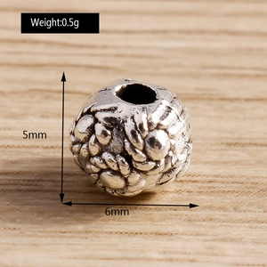 Macro detail of vintage silver barrel beads with embossed patterns for DIY jewelry making