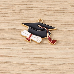 Vue détaillée d'une breloque chapeau de diplômé avec gland rouge et parchemin blanc