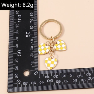 Detail of yellow and white checkered enamel heart keyrings with size and weight info
