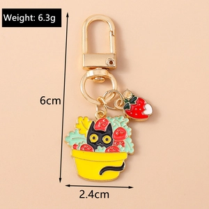 Porte-clés dessin animé chat noir dans un panier de fleurs avec breloque fraise