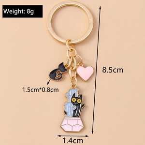 Detailed view showing the 8.5cm golden keychain with cartoon cat and cactus enamel charms