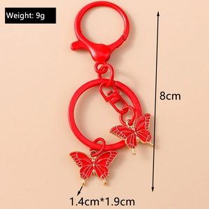 Detail view of red butterfly enamel keychain with size labels 8cm length and 9g weight