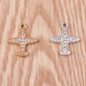 Détails macro des breloques avion en strass doré et argenté pour bijoux artisanaux