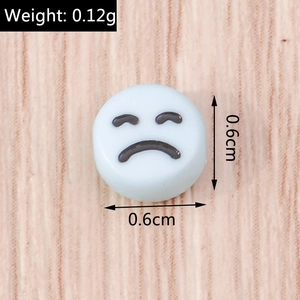 Dettaglio ravvicinato di una perla acrilica bianca da 6 mm con emoji triste stampata