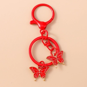 Close-up of red enamel double butterfly pendants with gold metal edges and key ring