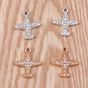 Vue macro de pendentifs avion avec strass en alliage doré et argenté pour bijoux DIY