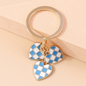 Detailed view of blue and white checkered heart charms on a golden metal keychain