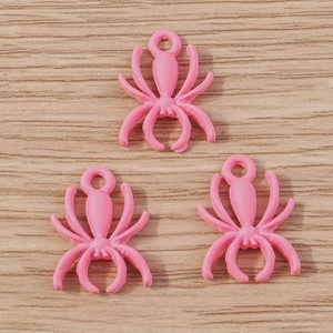 Detailed view of three bright pink spider charms with attachment loops for DIY jewelry