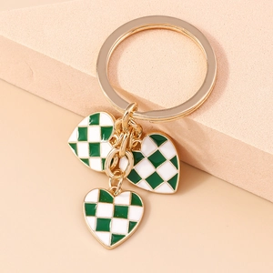 Detail view of heart-shaped checkerboard pendants on a golden keychain accessory