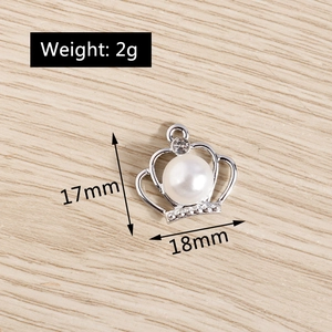 Detailed view of a silver crown charm with faux pearl and crystal inlays, 18mm size