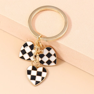 Detail showing high-quality gold alloy heart charms with black and white checkerboard pattern