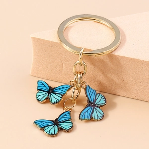 Détail des pendentifs papillon dégradé bleu avec un anneau porte-clés doré chic