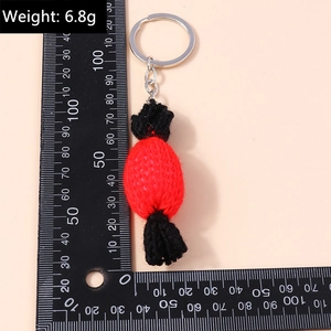 Détail macro d'un porte-clés bonbon au crochet fait main en rouge et noir avec anneau