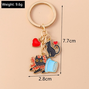 Detailed view of cute black cat alloy keychain with red heart and gold-tone hardware