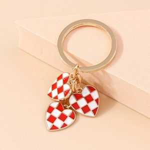 Detail of red and white checkered heart charms on gold-plated keychain with flat ring hook