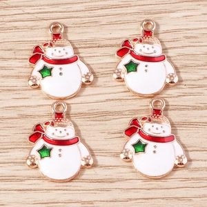 Macro view of four enamel snowman charms with red scarves on a light wooden surface