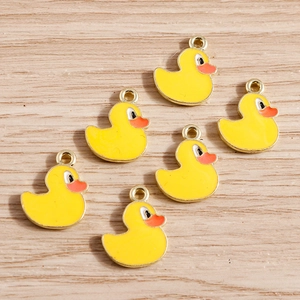 Detail of yellow enamel duck charms for DIY jewelry making with gold-tone alloy finish