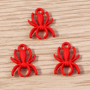 Detailed view of red spider charms with top holes for DIY jewelry and crafts design