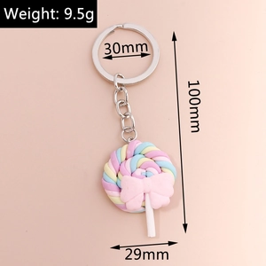 Macro detail of a colorful swirl lollipop keychain with a pink bow and silver ring