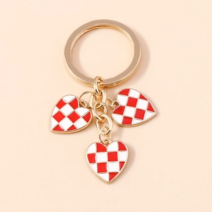 Detailed macro of golden keychain with red and white checkered enamel heart charms