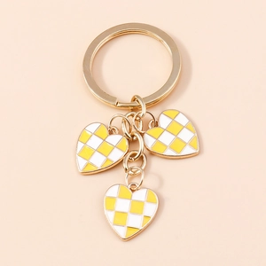 Detailed view of yellow checkered heart pendants on a golden metal keychain with rings