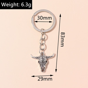 Detailed close-up of a vintage bull head keychain with intricate ethnic patterns