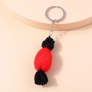 Détail du pendentif bonbon tricoté main rouge et noir avec porte-clés en métal argenté