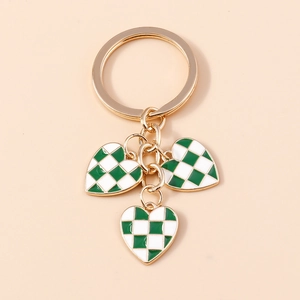Detail of checkered heart keychain with gold plating and green enamel heart pendants