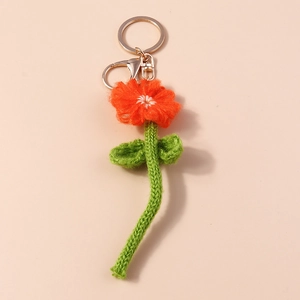 Détail d'un porte-clés fleur au crochet orange fait main avec fermoir mousqueton doré chic